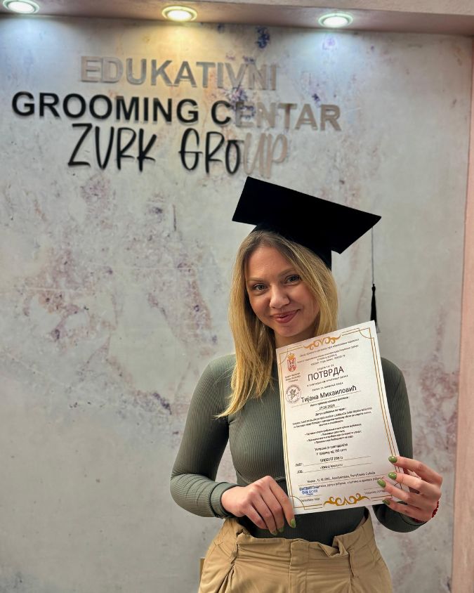 Srećan student kursa za šišanje pasa sa diplomom nakon završenog kursa.