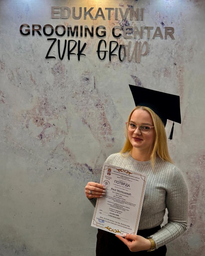 Devojka koja je uspešno završila kurs za šišanje pasa sa diplomom.