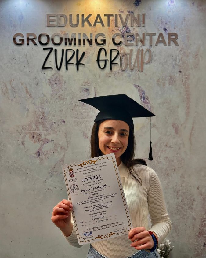 Srećna devojka nakon što je završila kurs za šišanje pasa i dobila diplomu.
