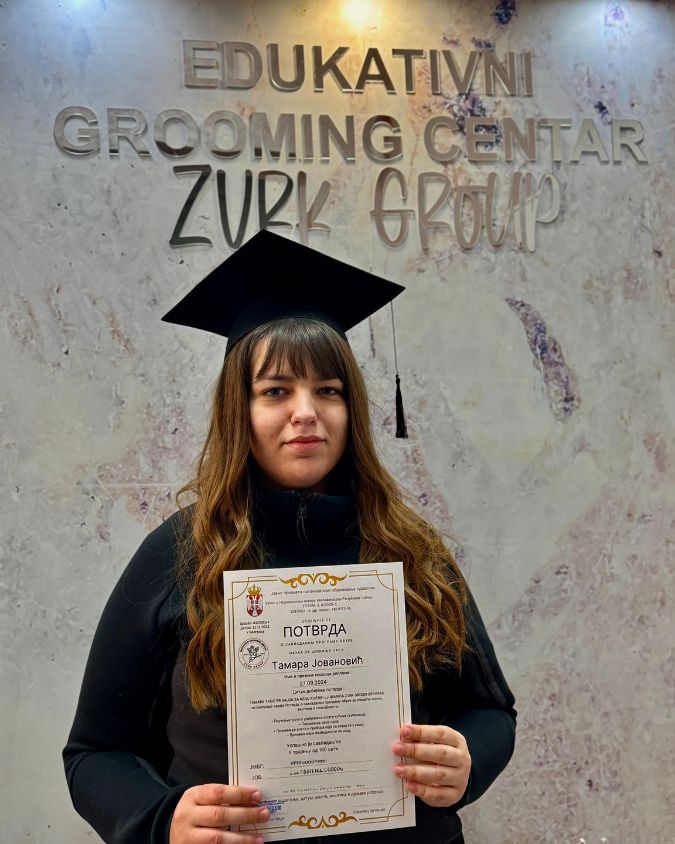 Žena koja je dobila diplomu za uspešno završen kurs za šišanje pasa.