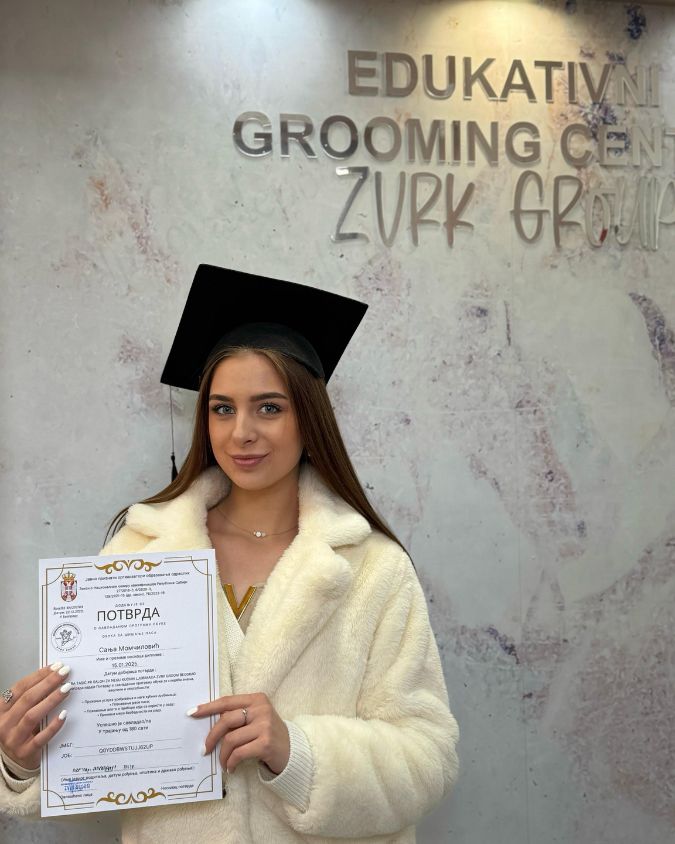 Zadovoljan student kursa za grooming sa diplomom u ruci.